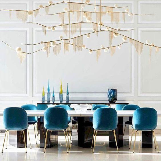 Gold white lighting fixtures hanging above a fancy table.