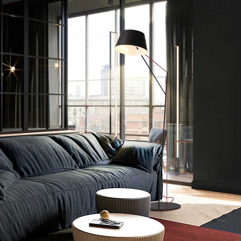 Black vintage floor lamp placed beside a sofa and small round chairs