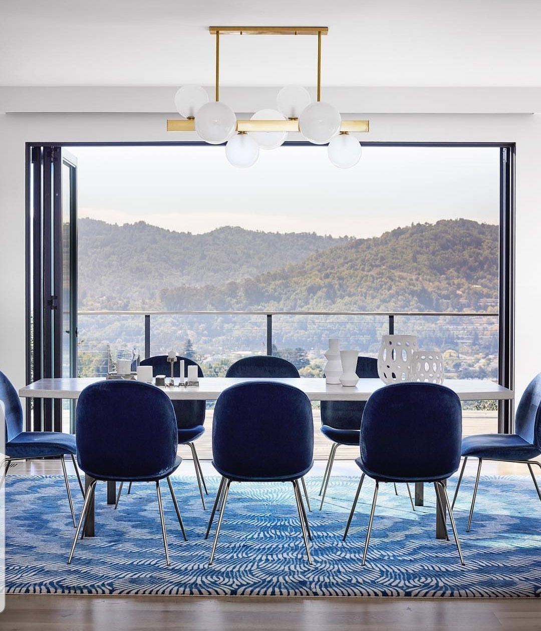 A blue dining room with a chandelier hanging above