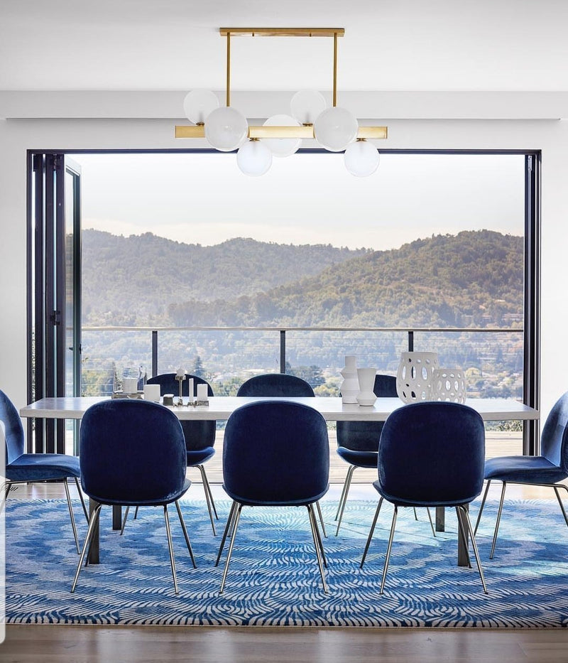 A blue dining room with a chandelier hanging above