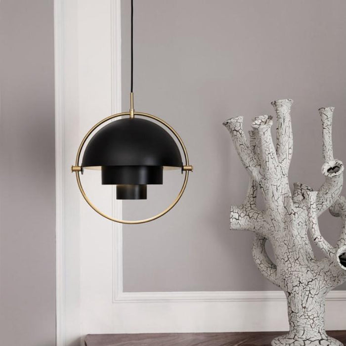 Black multi-lite pendant light hung beside a coral-like design