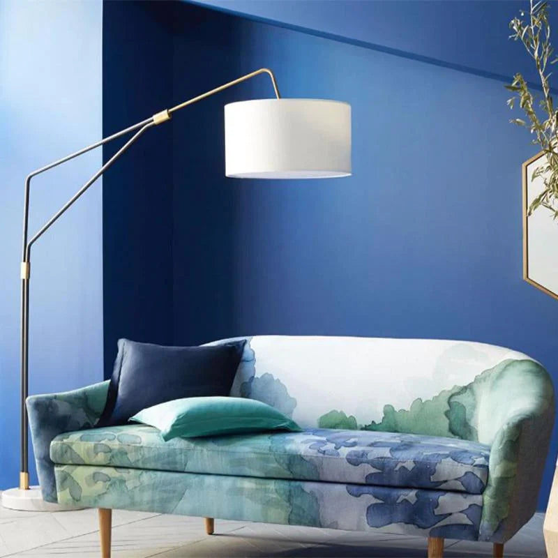 White floor lamp beside a green and blue colored sofa