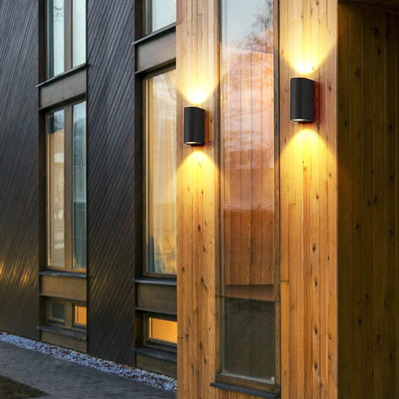 Black outdoor light installed in the wall of the wooden house