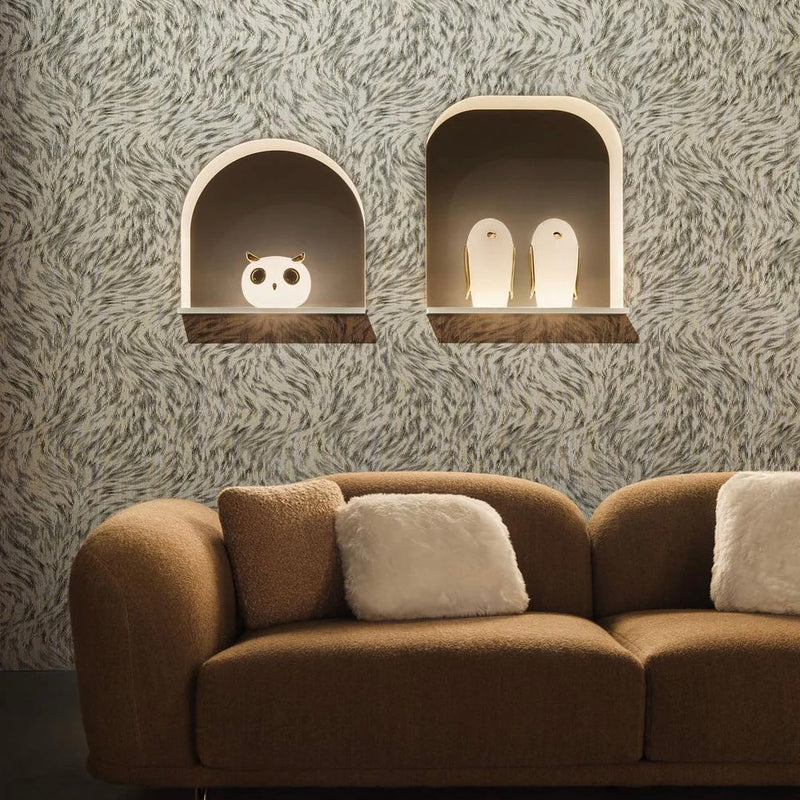 Owl and penguin-shaped table lamps placed above a brown sofa